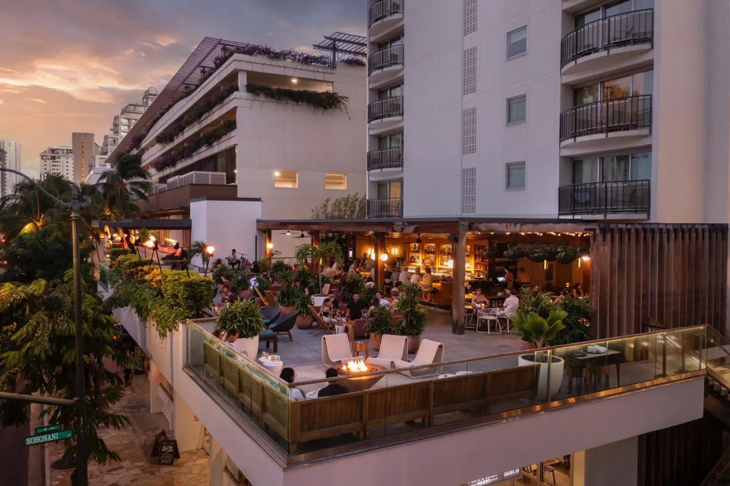 Elevated terrace with guests at sunset at The Laylow Waikiki, Autograph Collection.
