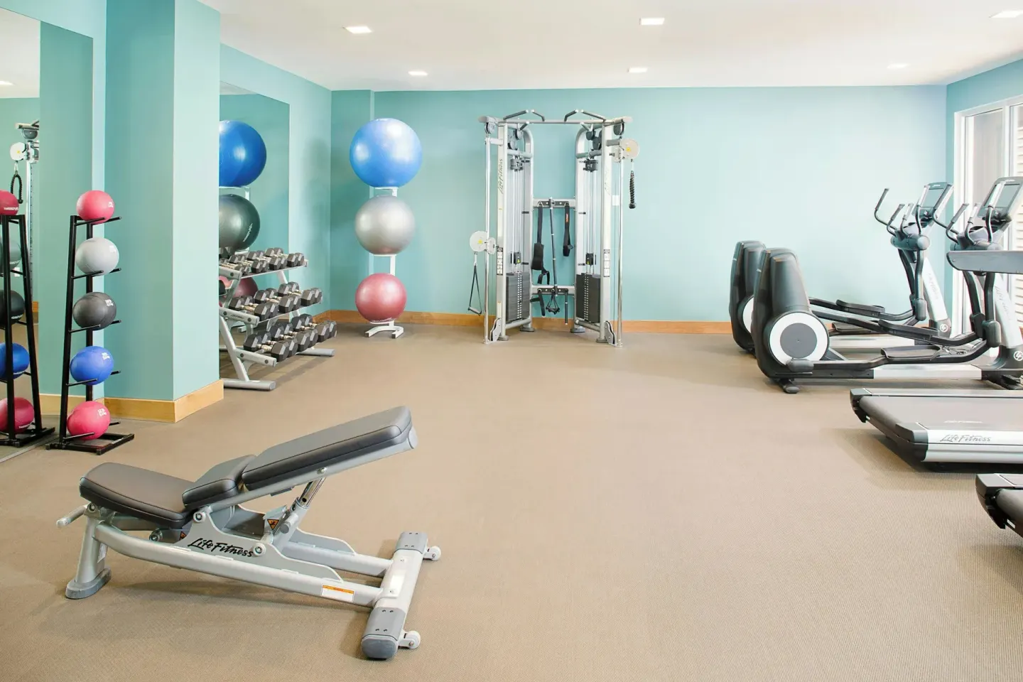 Fitness center with weights and cardio equipment at The Laylow Waikiki, Autograph Collection.