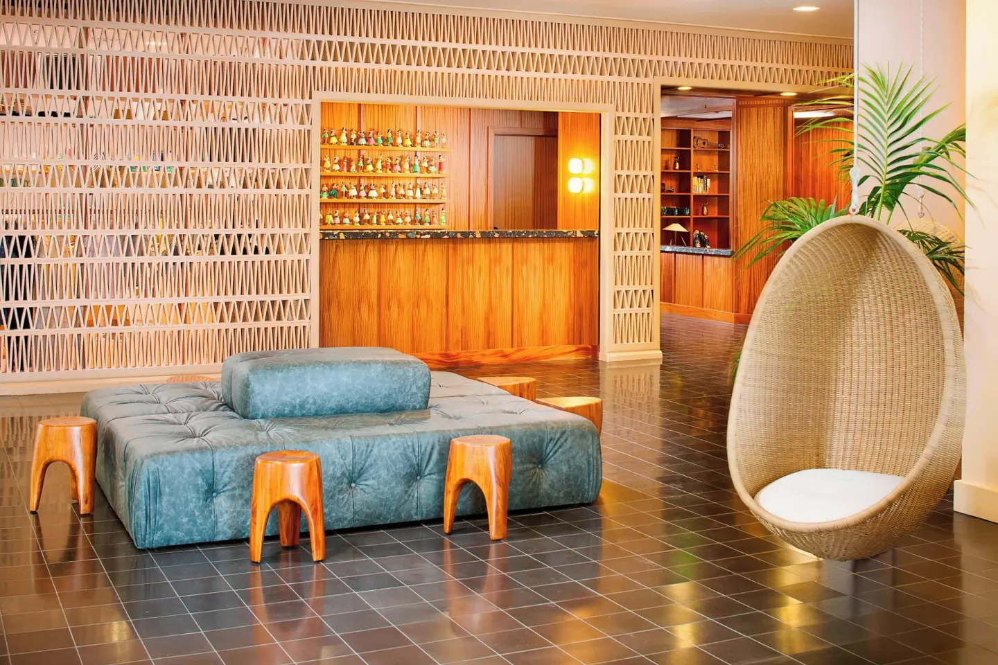 Lobby seating and wood reception desk at The Laylow Waikiki, Autograph Collection.