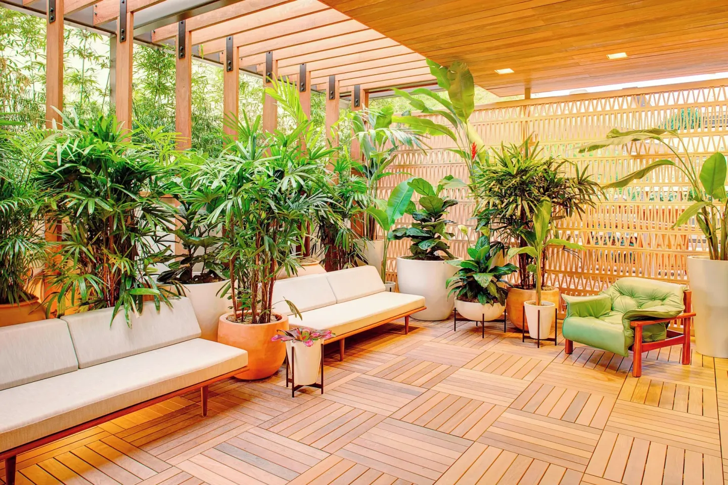 Plant-filled lanai seating area at The Laylow Waikiki, Autograph Collection.