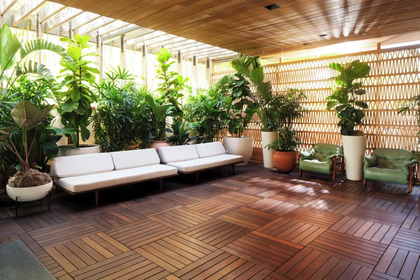 Shaded garden seating with benches and potted plants at The Laylow Waikiki, Autograph Collection.