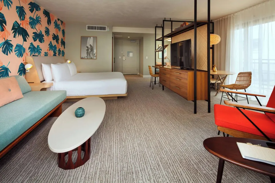 Corner Suite with king bed, daybed and lounge seating at The Laylow Waikiki, Autograph Collection.