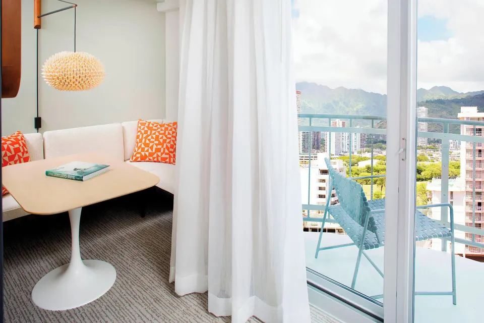 Corner Suite dining nook and balcony with mountain view at The Laylow Waikiki, Autograph Collection.