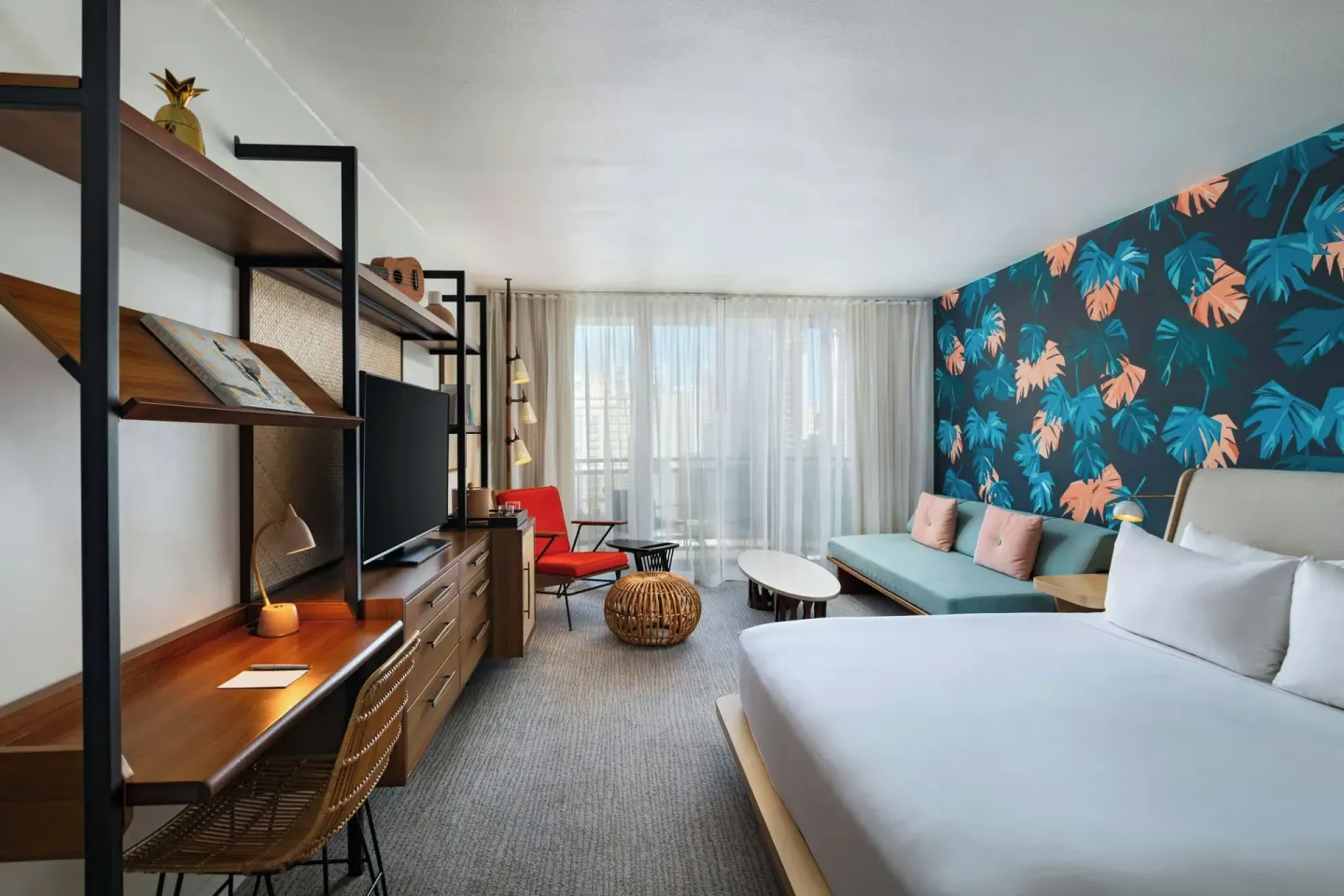 King bed and daybed guestroom with balcony doors at The Laylow Waikiki, Autograph Collection.