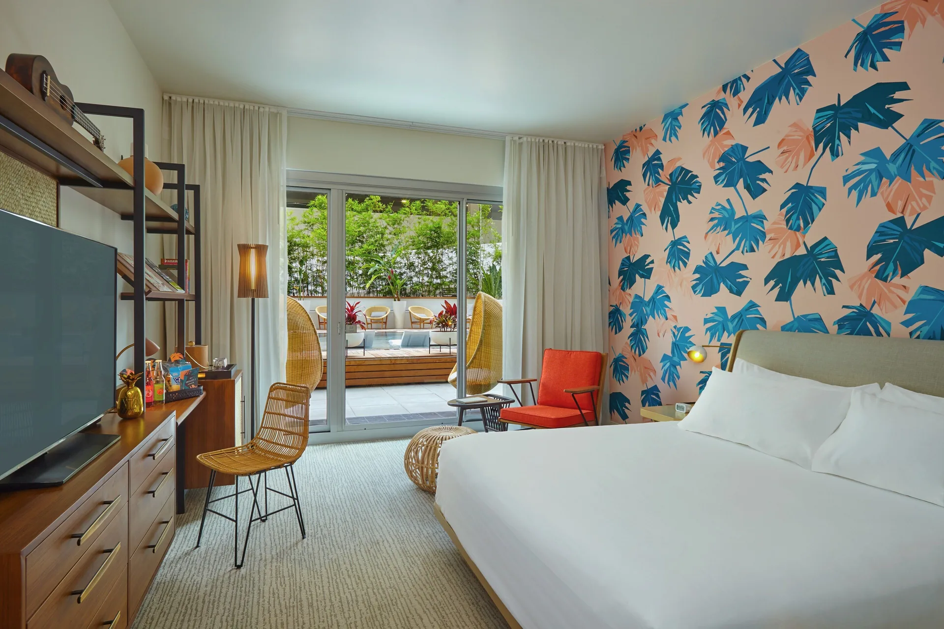 Poolside Patio guest room with king bed and outdoor seating at The Laylow Waikiki, Autograph Collection.