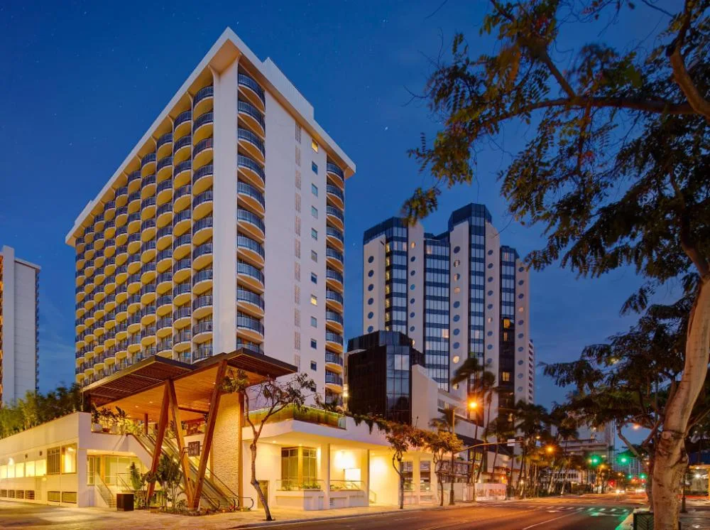 Exterior tower and balconies of The Laylow Waikiki, Autograph Collection at dusk.