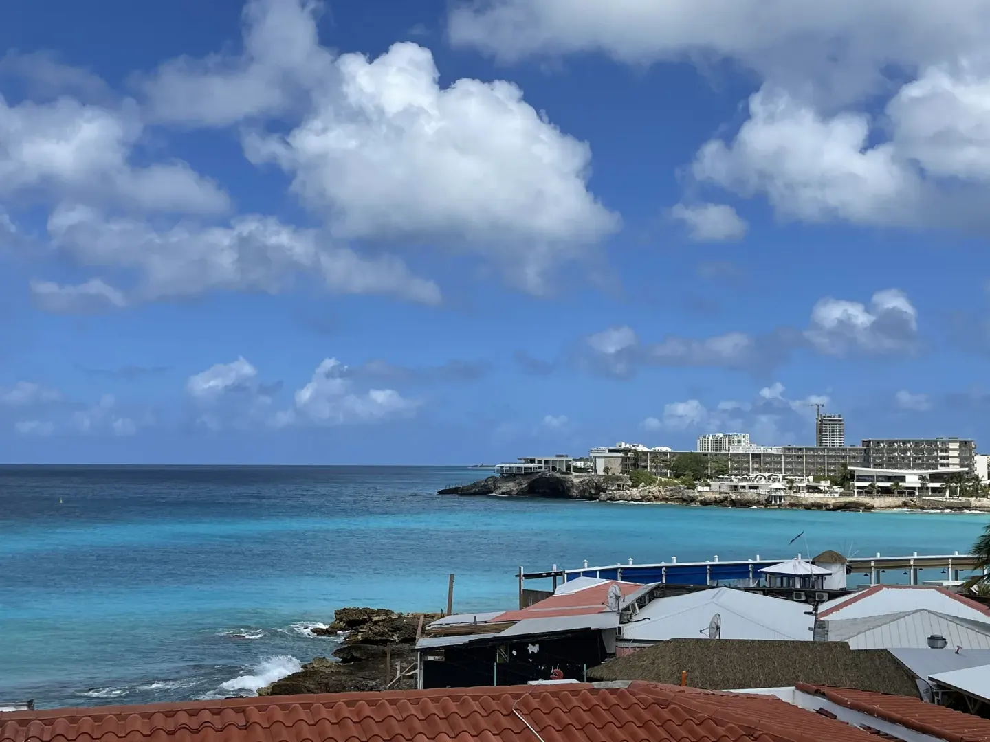 Coastal view near The Morgan Resort Spa Village with turquoise sea, rooftops, and cliffs.