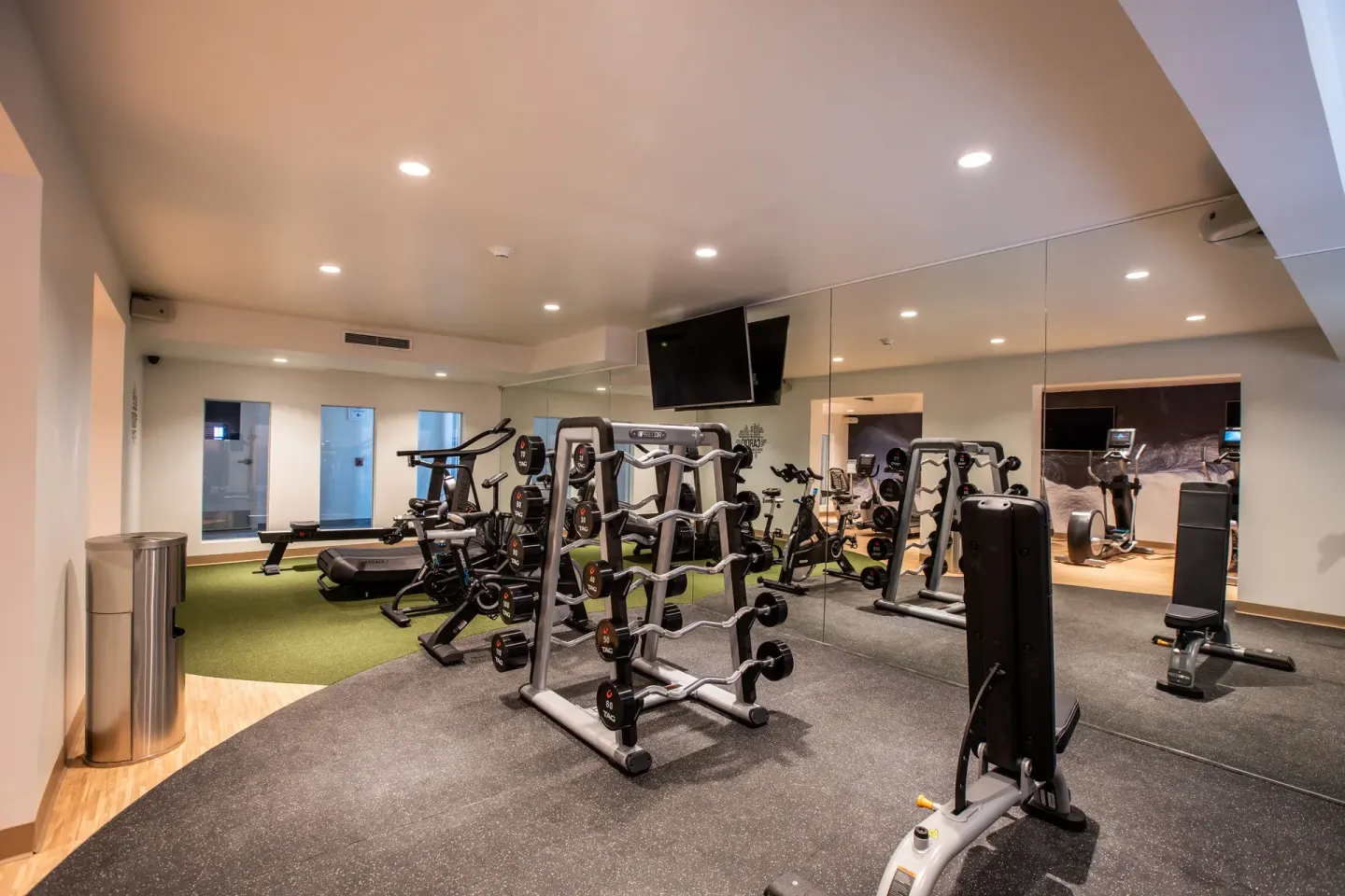 Weight racks, cardio machines and mirrors in the gym at The Morgan Resort Spa Village.