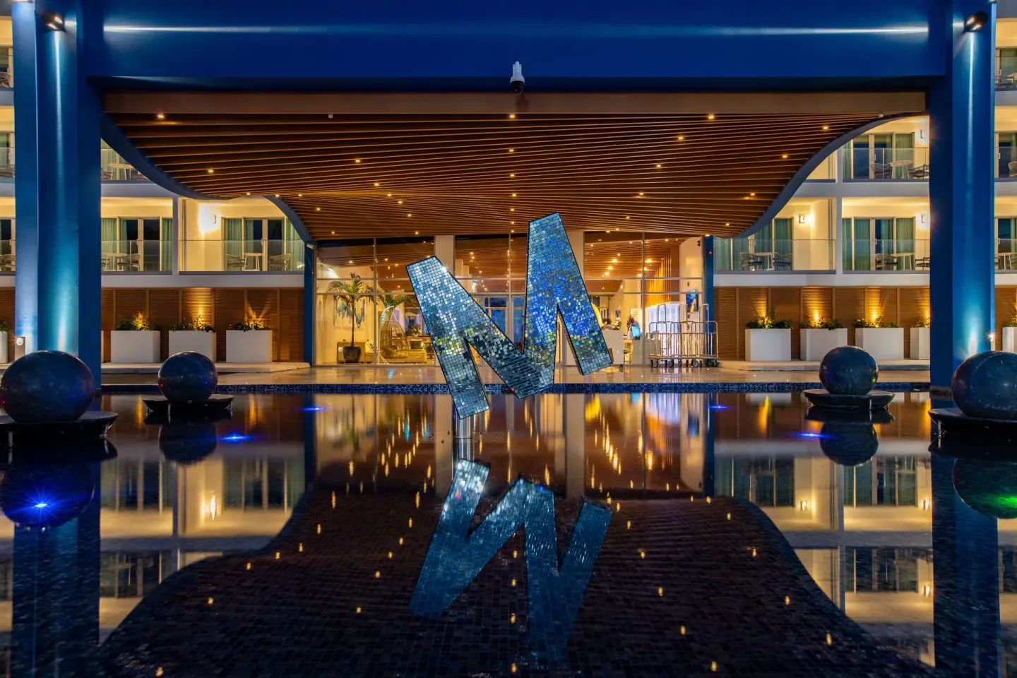 Night view of the resort entrance and reflecting pool at The Morgan Resort Spa Village.