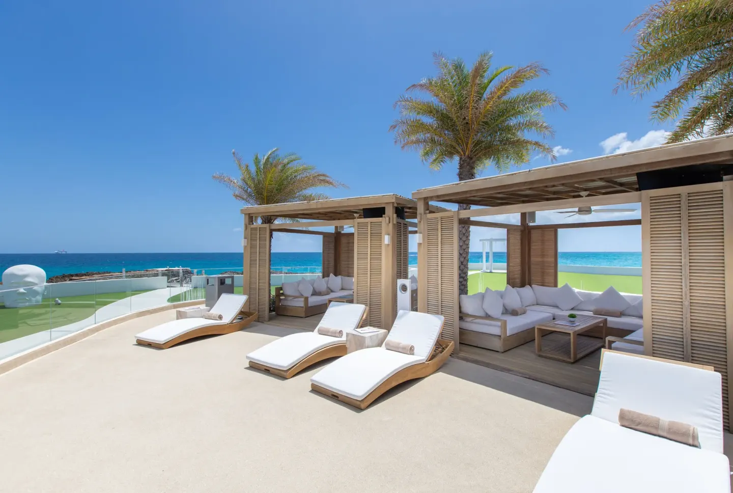 Private cabanas and white loungers overlooking the sea at The Morgan Resort Spa Village.