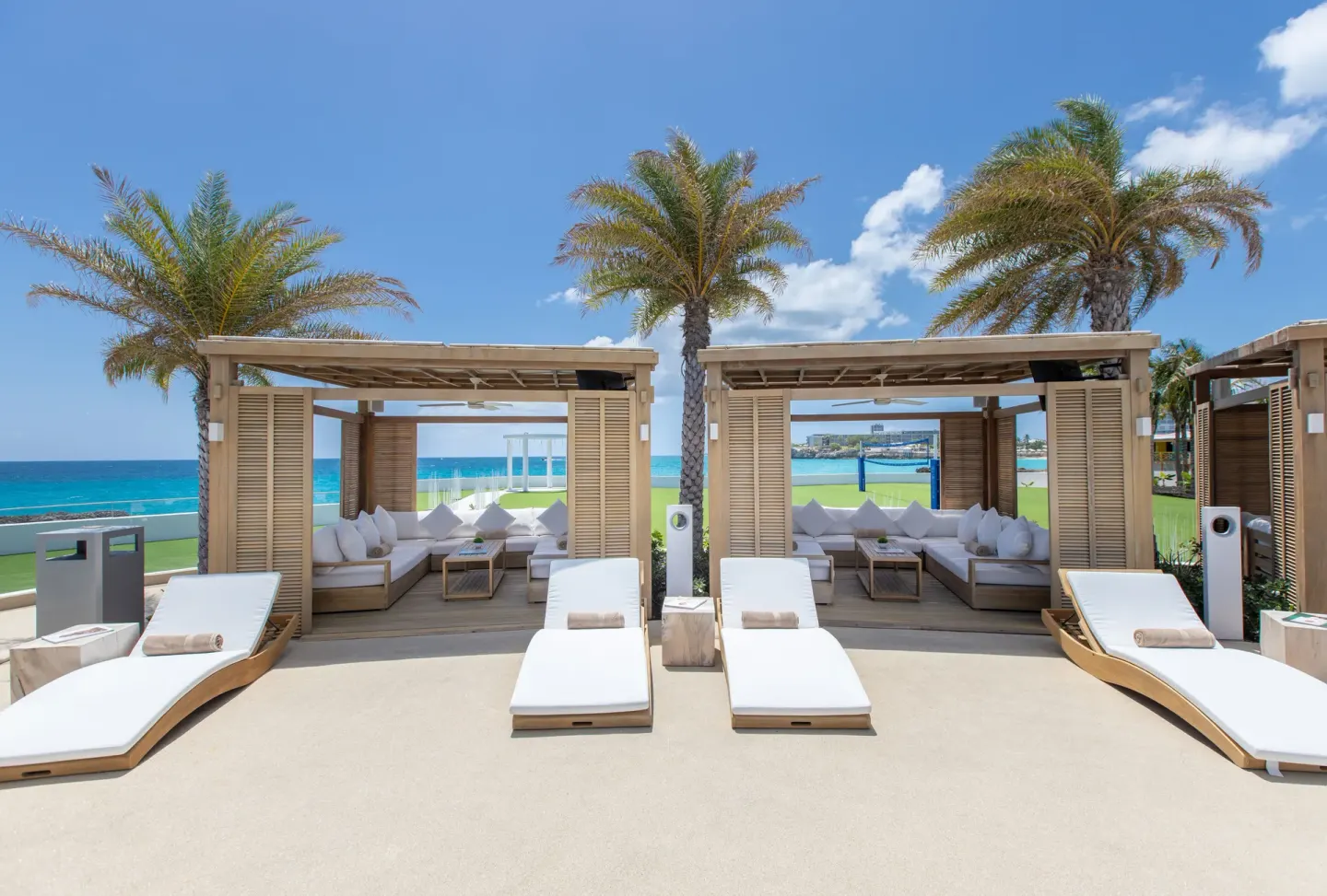 Poolside cabanas and loungers facing the ocean at The Morgan Resort Spa Village.