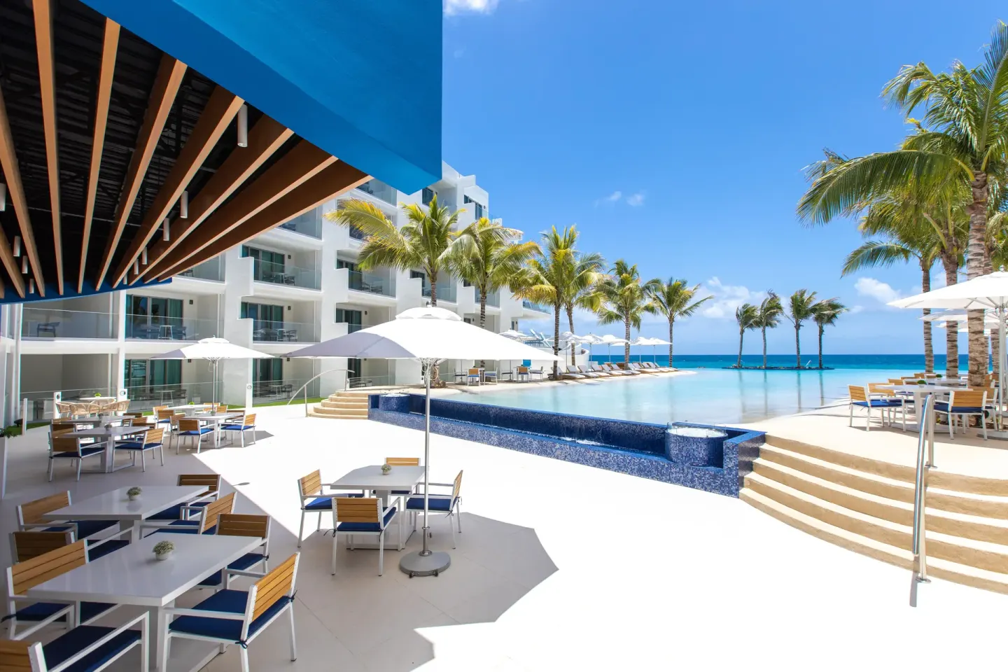 Poolside terrace with umbrellas and ocean views at The Morgan Resort Spa Village.