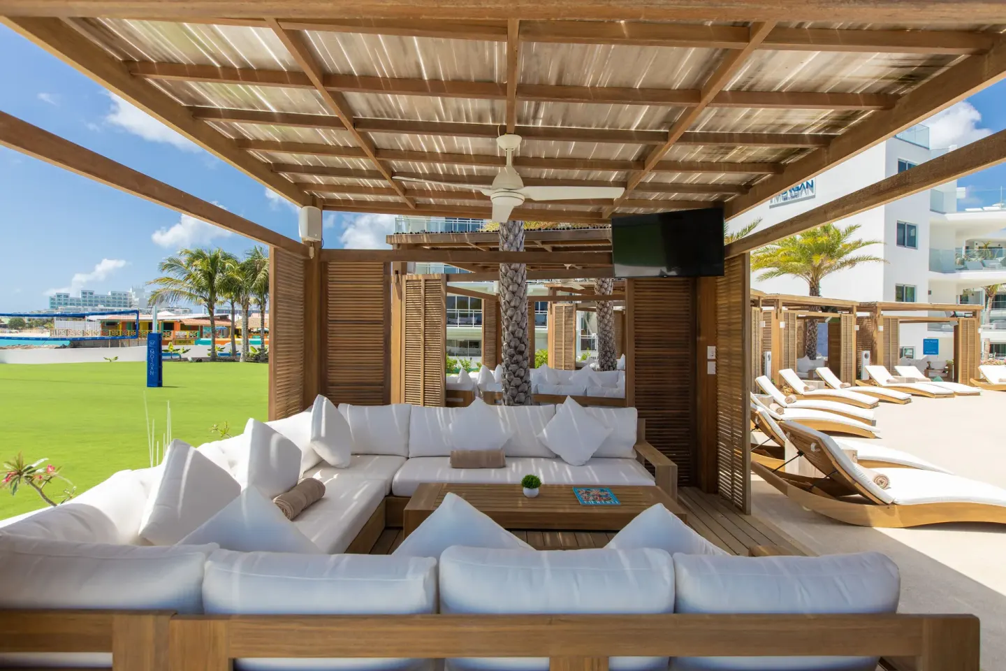 Shaded cabana lounge with white cushions at The Morgan Resort Spa Village.