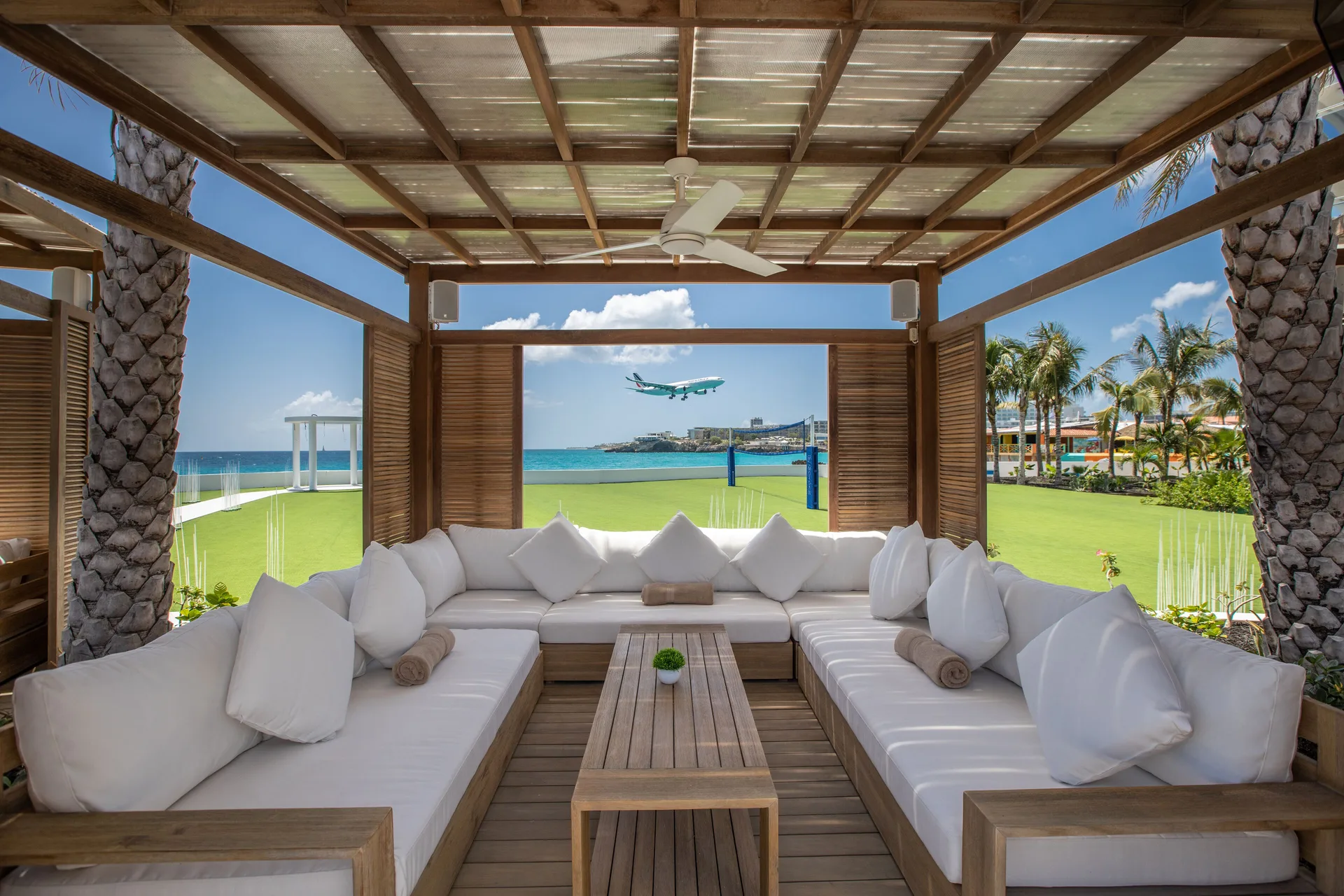 Shaded cabana lounge with ocean and runway view at The Morgan Resort Spa Village.