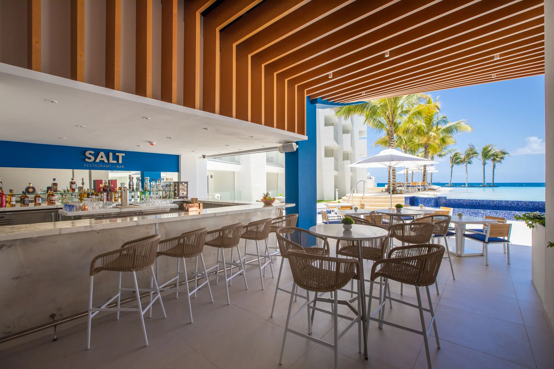 Open-air poolside bar and seating at The Morgan Resort Spa Village.