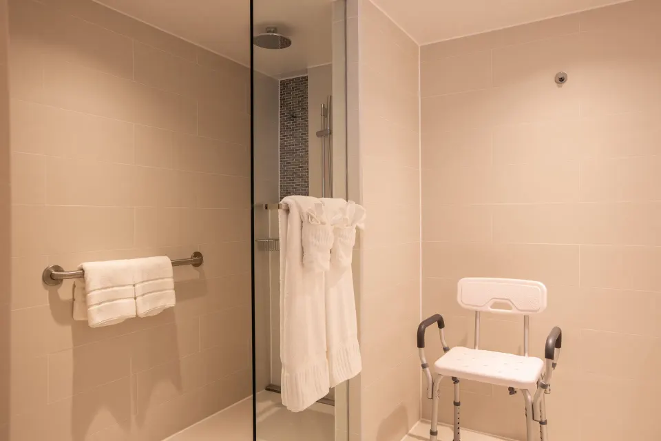 Accessible bathroom shower with grab bar and shower chair at The Morgan Resort Spa Village.