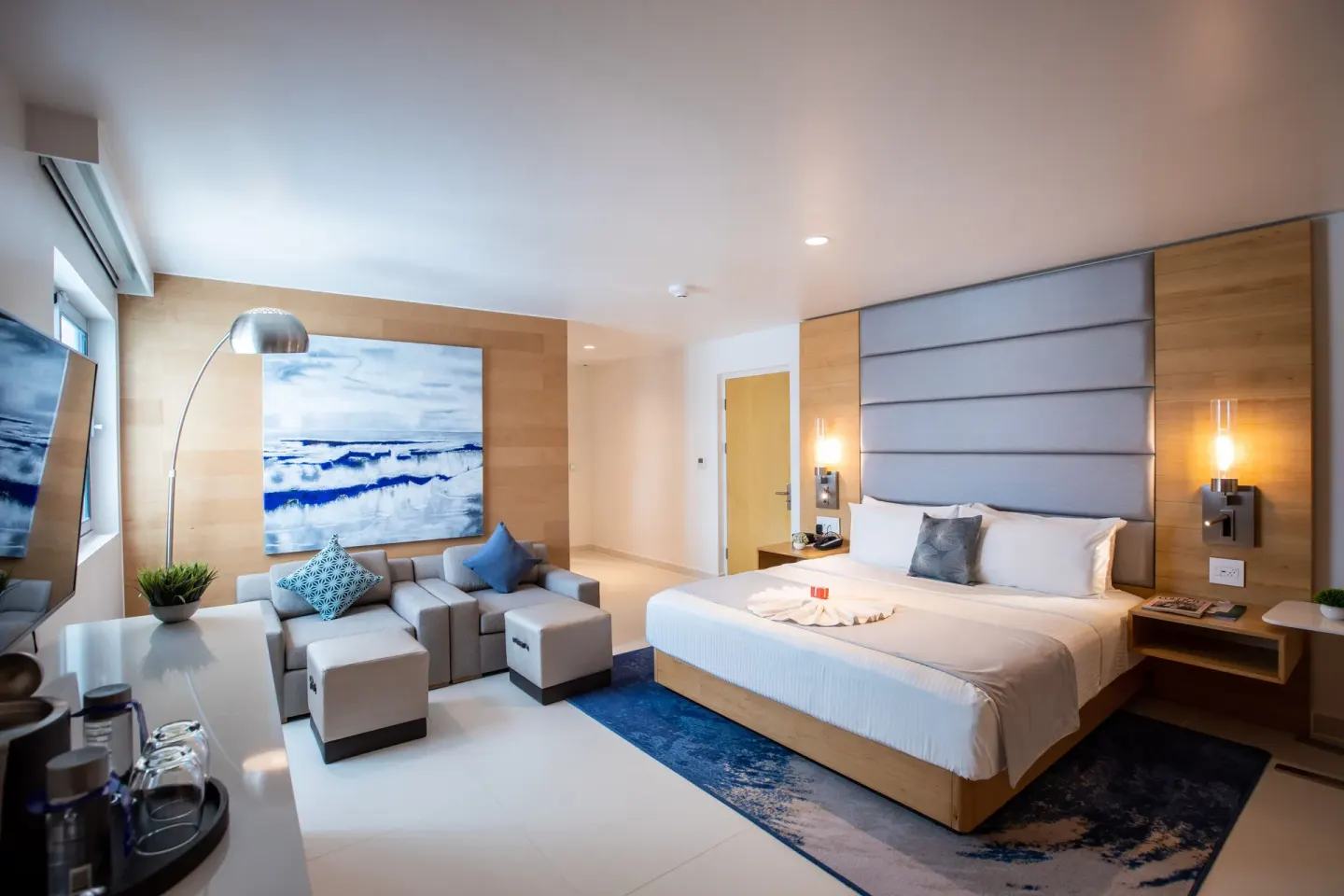 Accessible guestroom king bed, sofa seating, and artwork at The Morgan Resort Spa Village.
