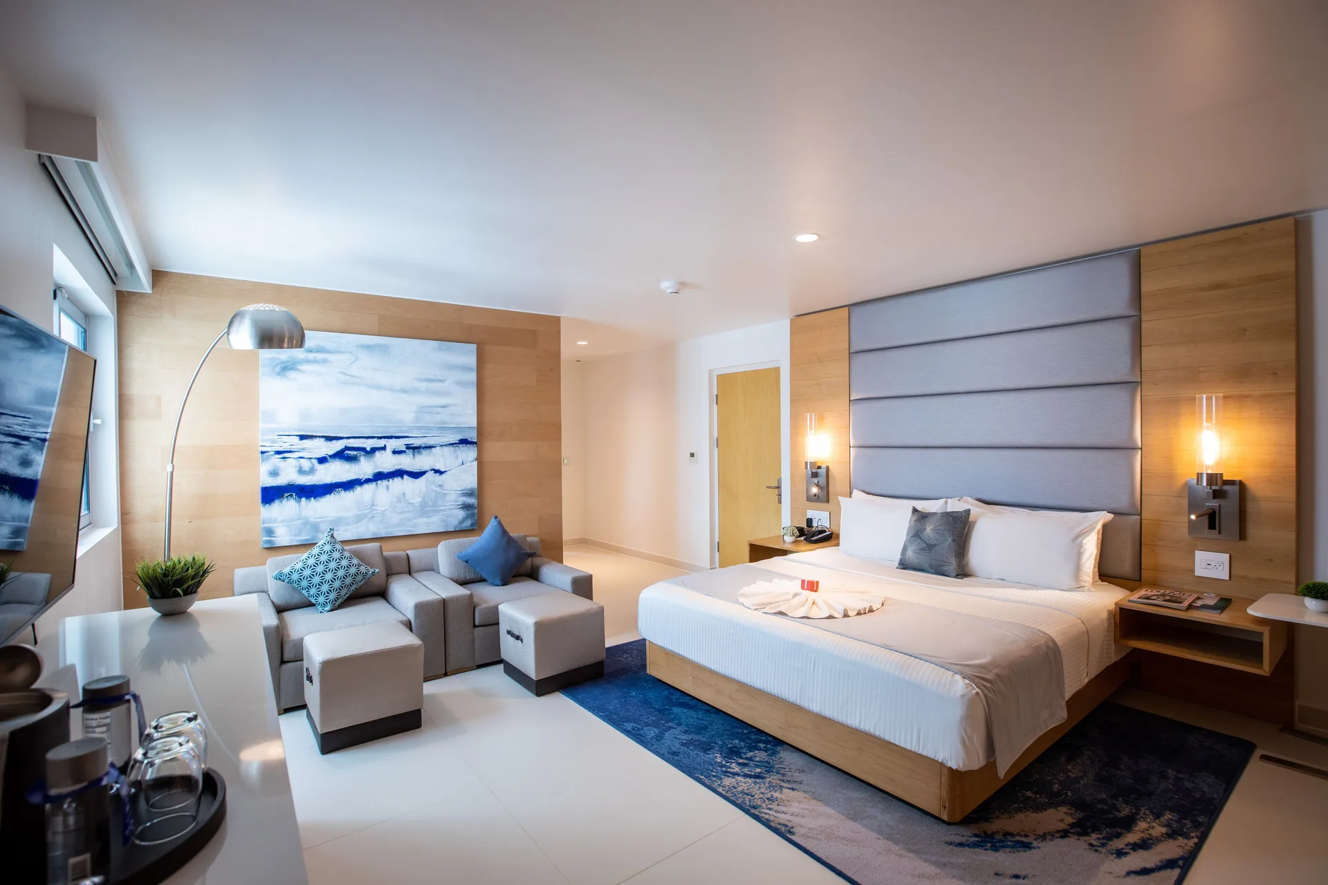 Accessible guestroom king bed, sofa seating, and artwork at The Morgan Resort Spa Village.