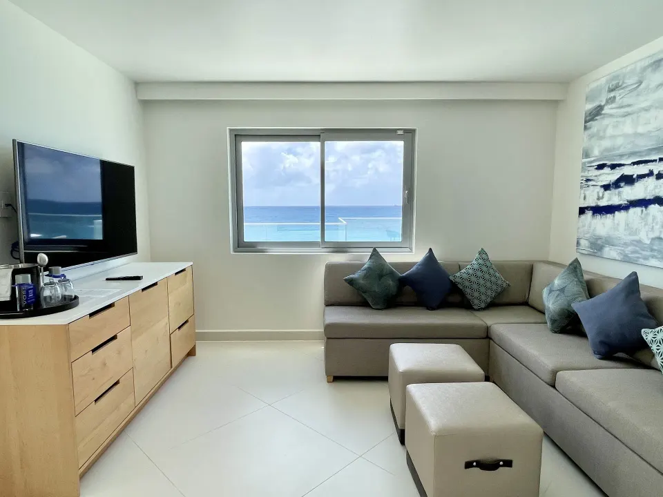 Deluxe Oceanfront Suite lounge with sofa and ocean window at The Morgan Resort Spa Village.