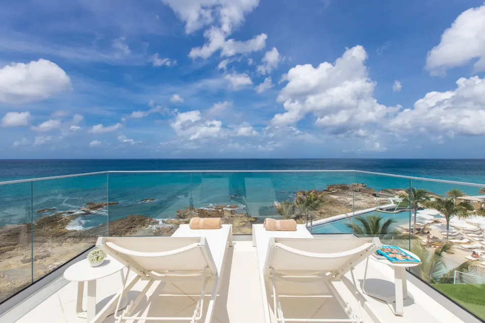Deluxe Oceanfront Suite terrace loungers overlooking the sea at The Morgan Resort Spa Village.