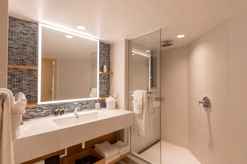 Junior Oceanfront Suite bathroom with vanity and glass shower at The Morgan Resort Spa Village.
