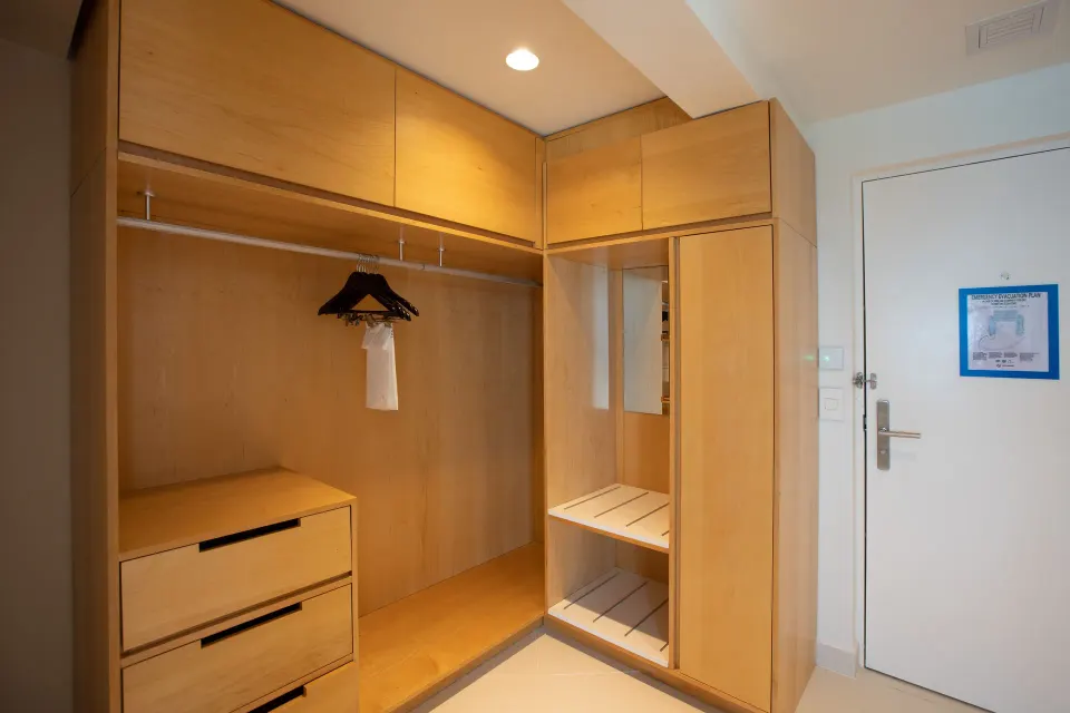 Junior Oceanfront Suite entry closet with wood cabinetry at The Morgan Resort Spa Village.