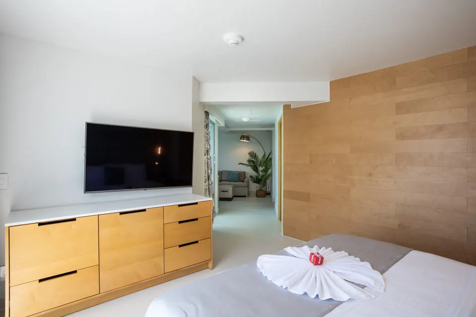 Junior Oceanfront Suite king bed, TV console, and sitting area at The Morgan Resort Spa Village.