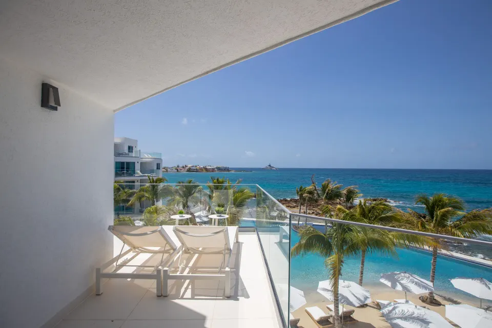 Junior Oceanfront Suite terrace with loungers and ocean view at The Morgan Resort Spa Village.
