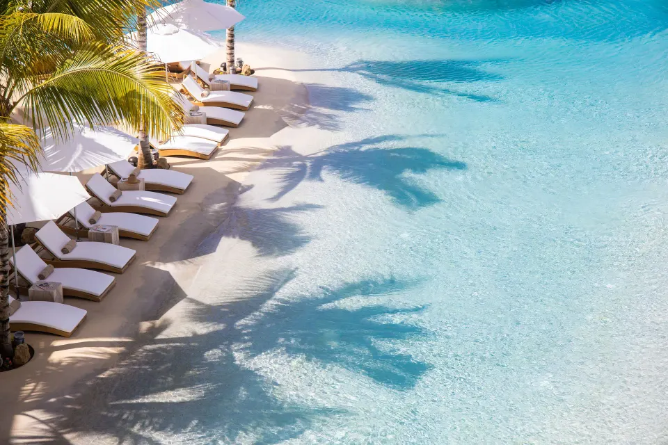 Oceanview guestroom balcony view of loungers and turquoise water at The Morgan Resort Spa Village.