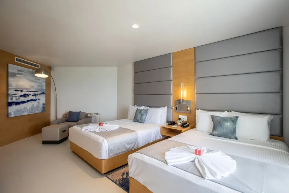 Pool View guest room with two beds and seating at The Morgan Resort Spa Village.