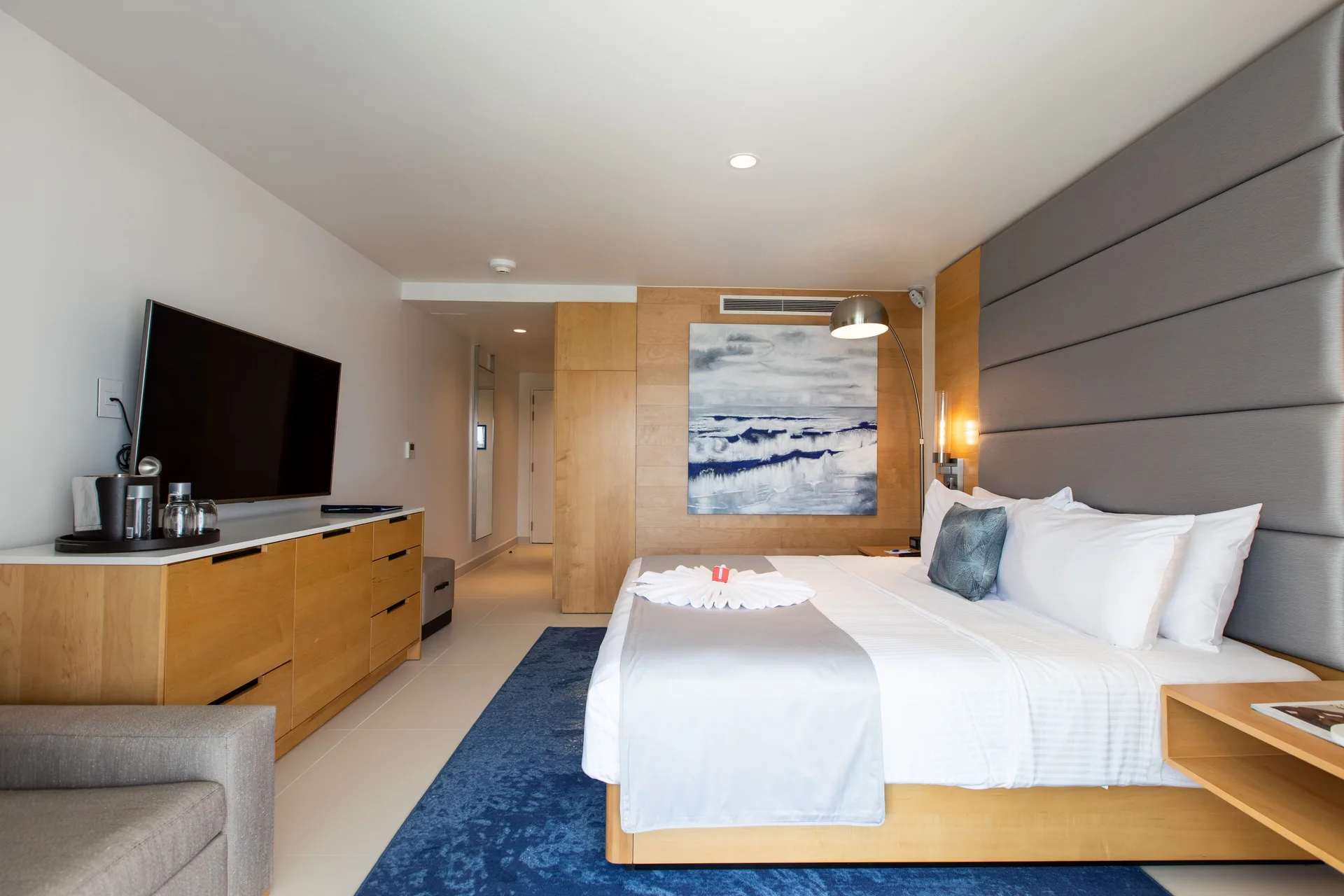 Runway View Guestroom king bed and media console at The Morgan Resort Spa Village.