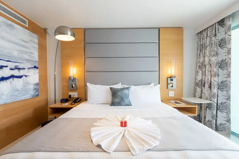 Runway View Guestroom king bed with wall art at The Morgan Resort Spa Village.