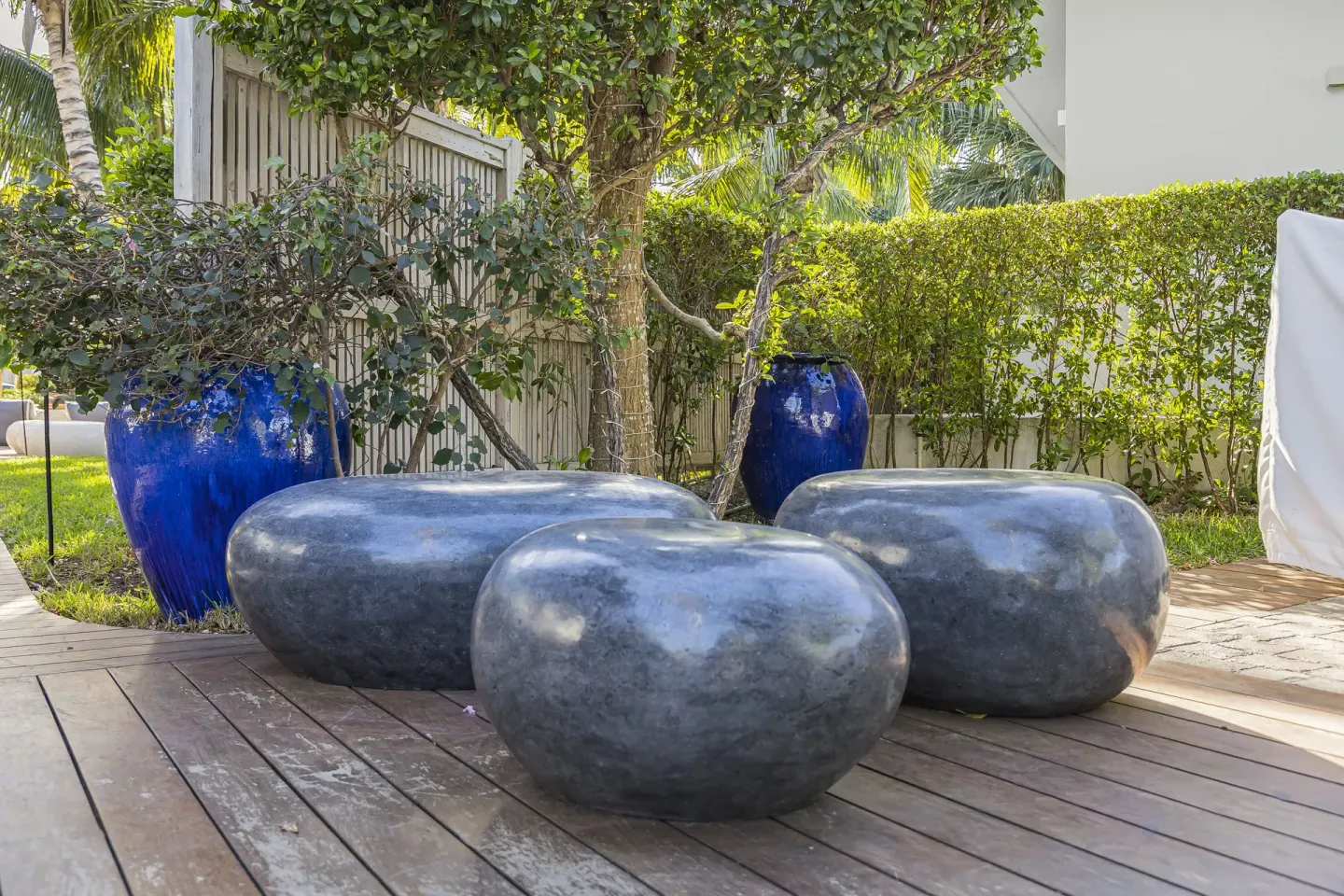 Garden deck with stone stools and blue planters at The Oasis at Grace Bay.