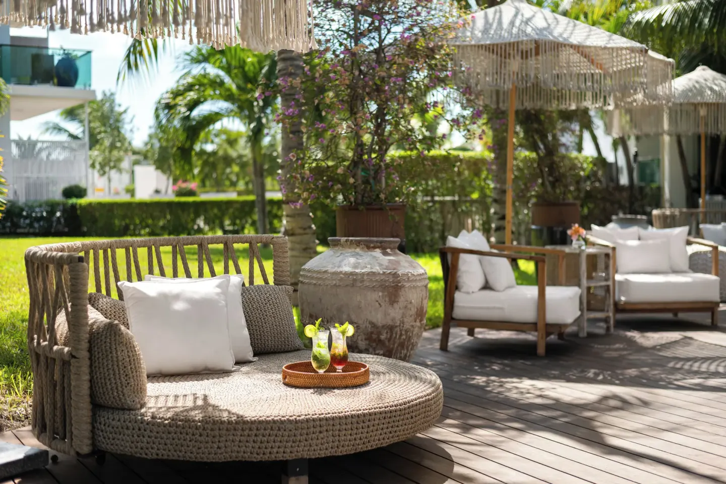 Outdoor lounge seating with drinks in the gardens at The Oasis at Grace Bay.