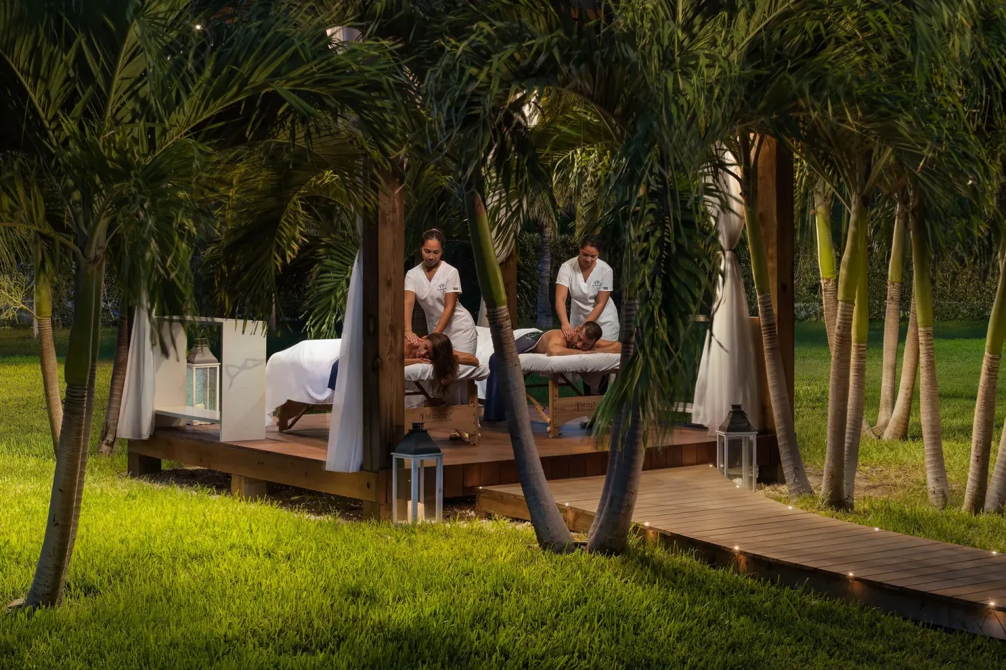 Outdoor couples massage pavilion among palms at The Oasis at Grace Bay.
