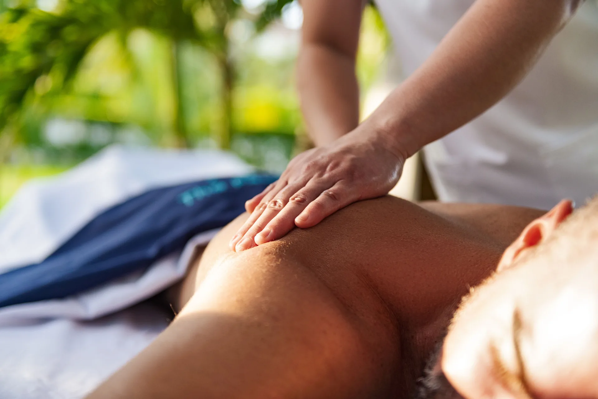 Close-up of a back massage in a tropical setting at The Oasis at Grace Bay.