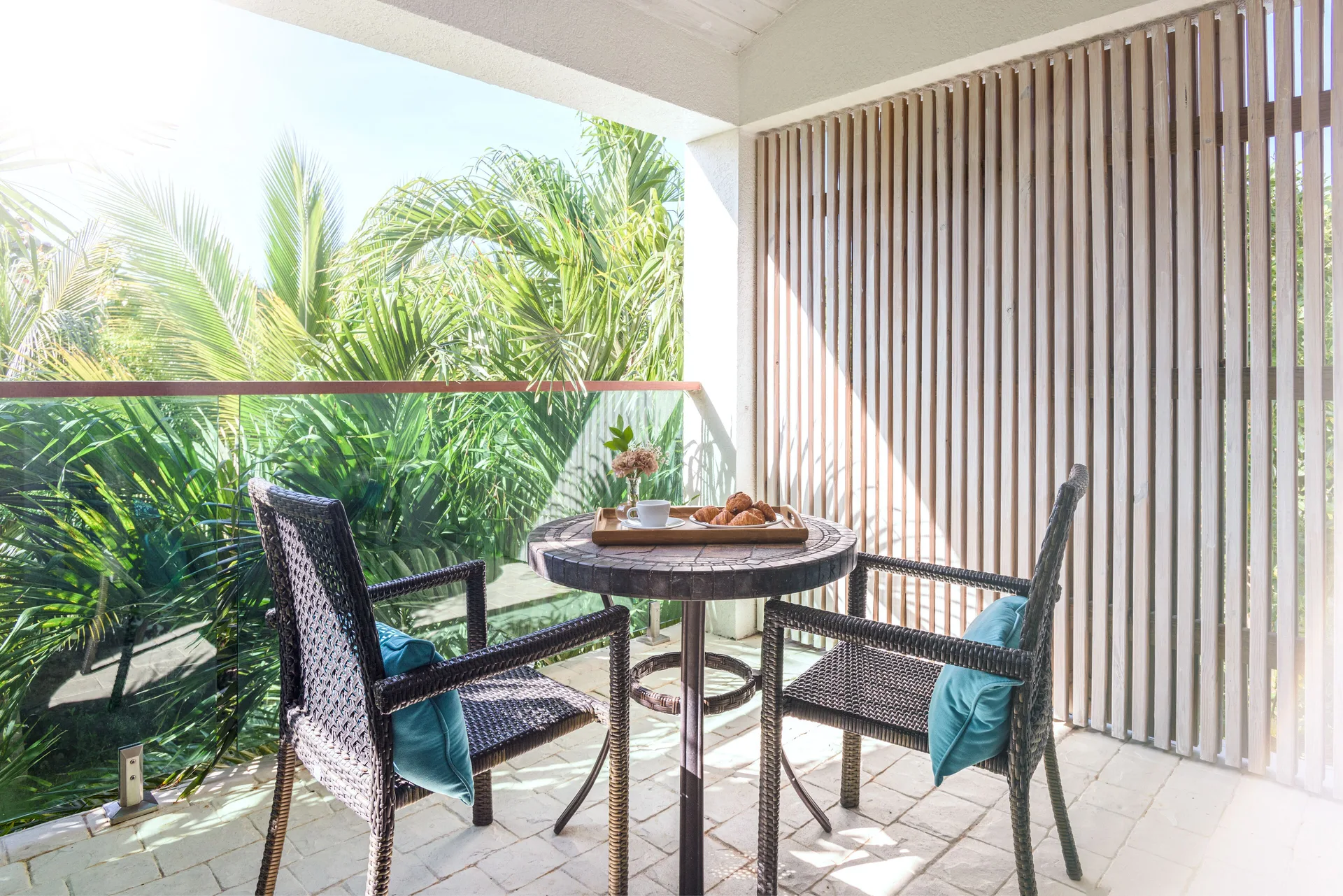 Second Level Pool Suite balcony seating with palms at The Oasis at Grace Bay.