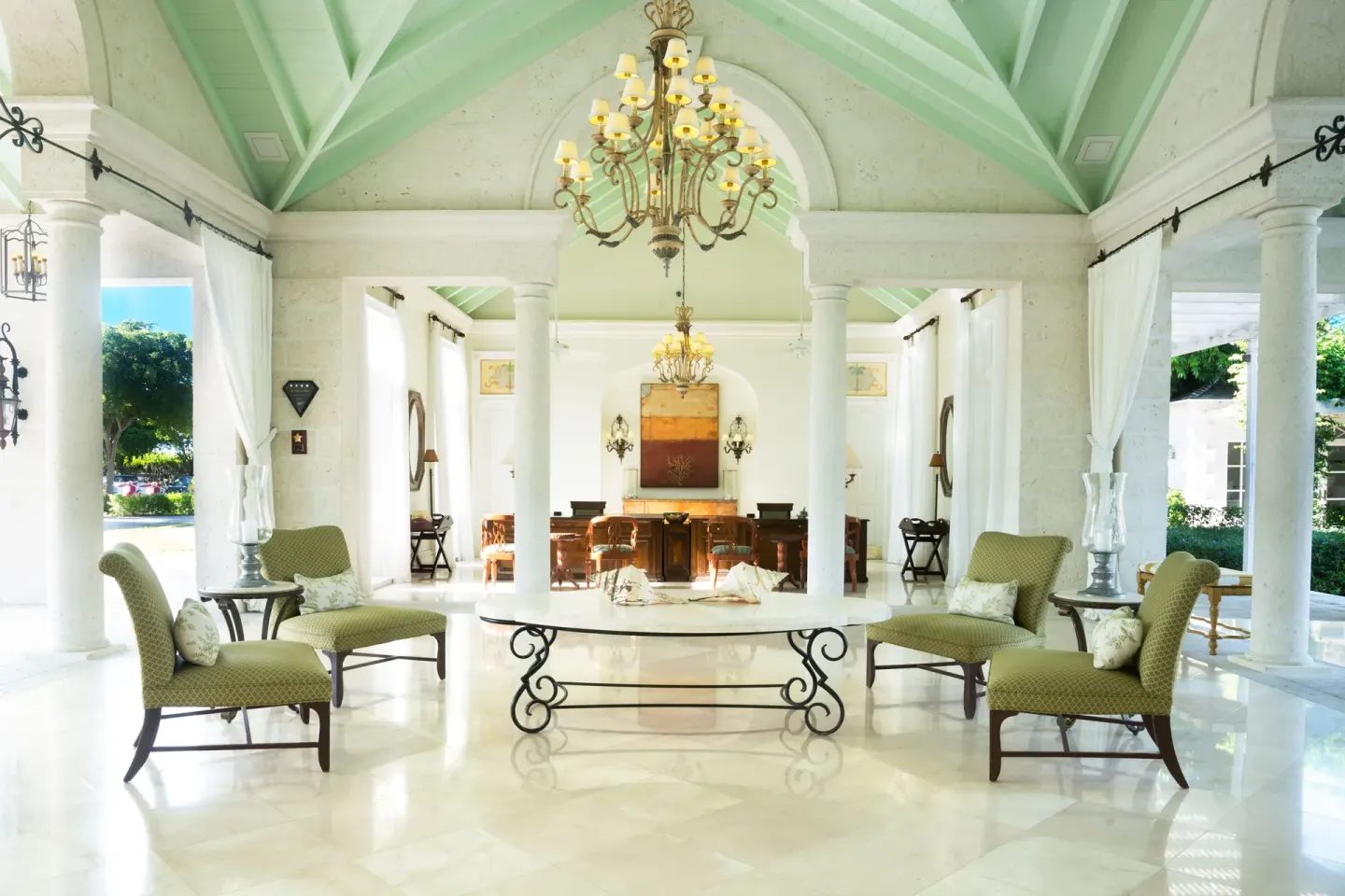 Open-air lobby seating with columns and chandeliers at The Palms Turks and Caicos.