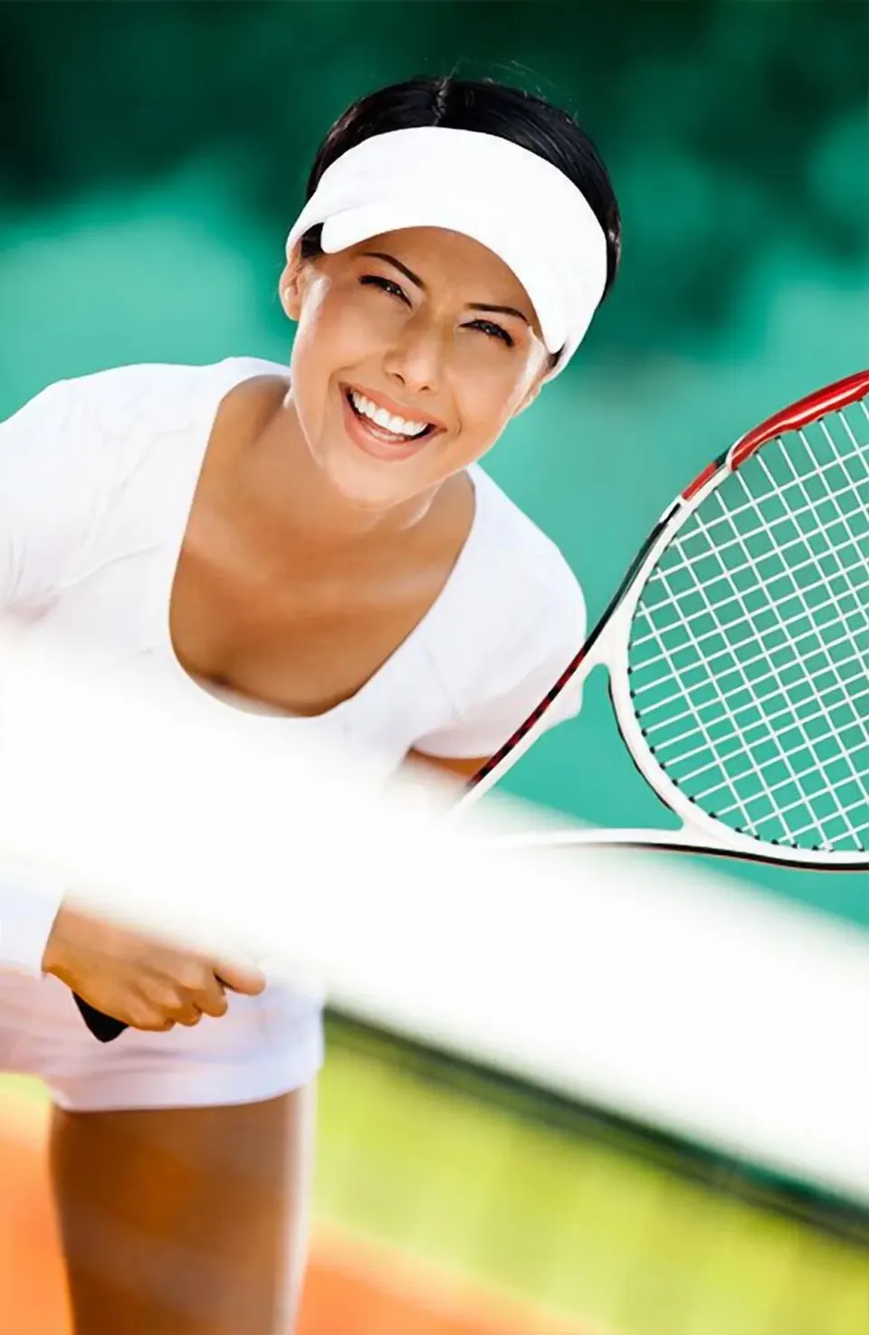 Tennis player smiling with a racket at The Palms Turks and Caicos.