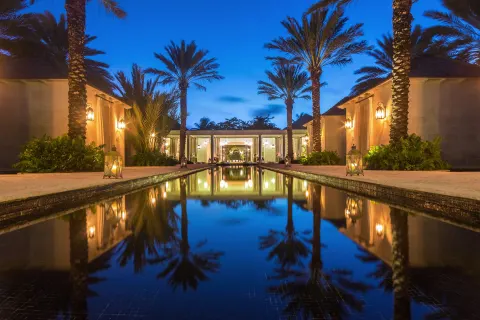 Reflecting pool and palms at twilight at The Palms Turks and Caicos.