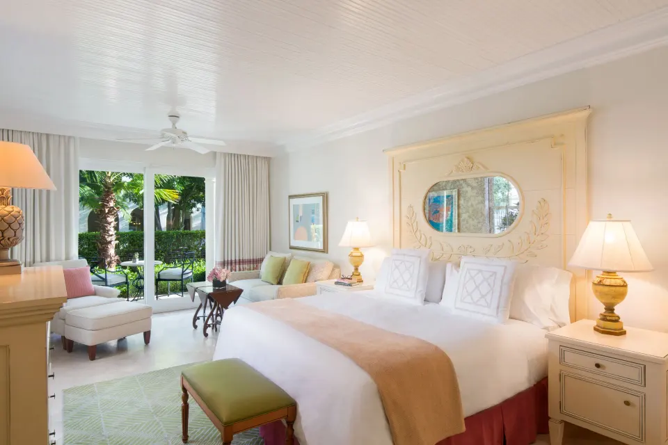 Junior Suite king bed with seating area and garden patio at The Palms Turks and Caicos.