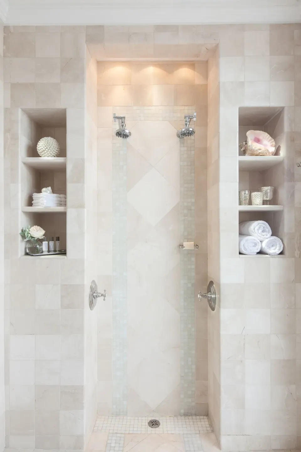 Marble walk-in shower with shelves in a pool view suite at The Palms Turks and Caicos.