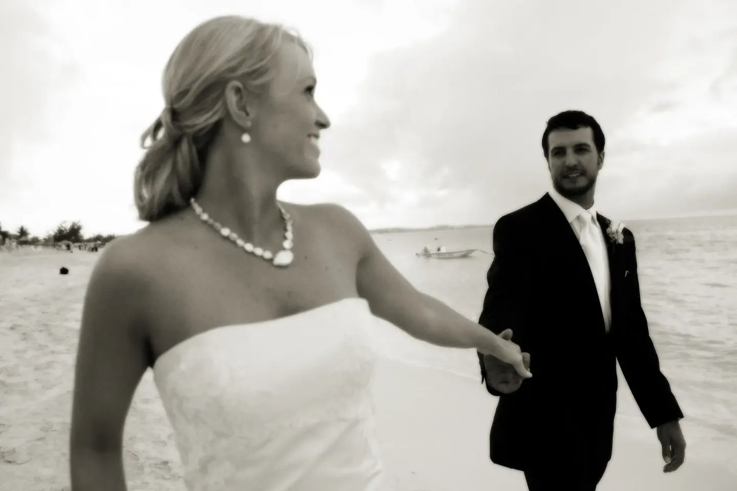 Bride and groom walking hand in hand on the beach at The Palms Turks and Caicos.