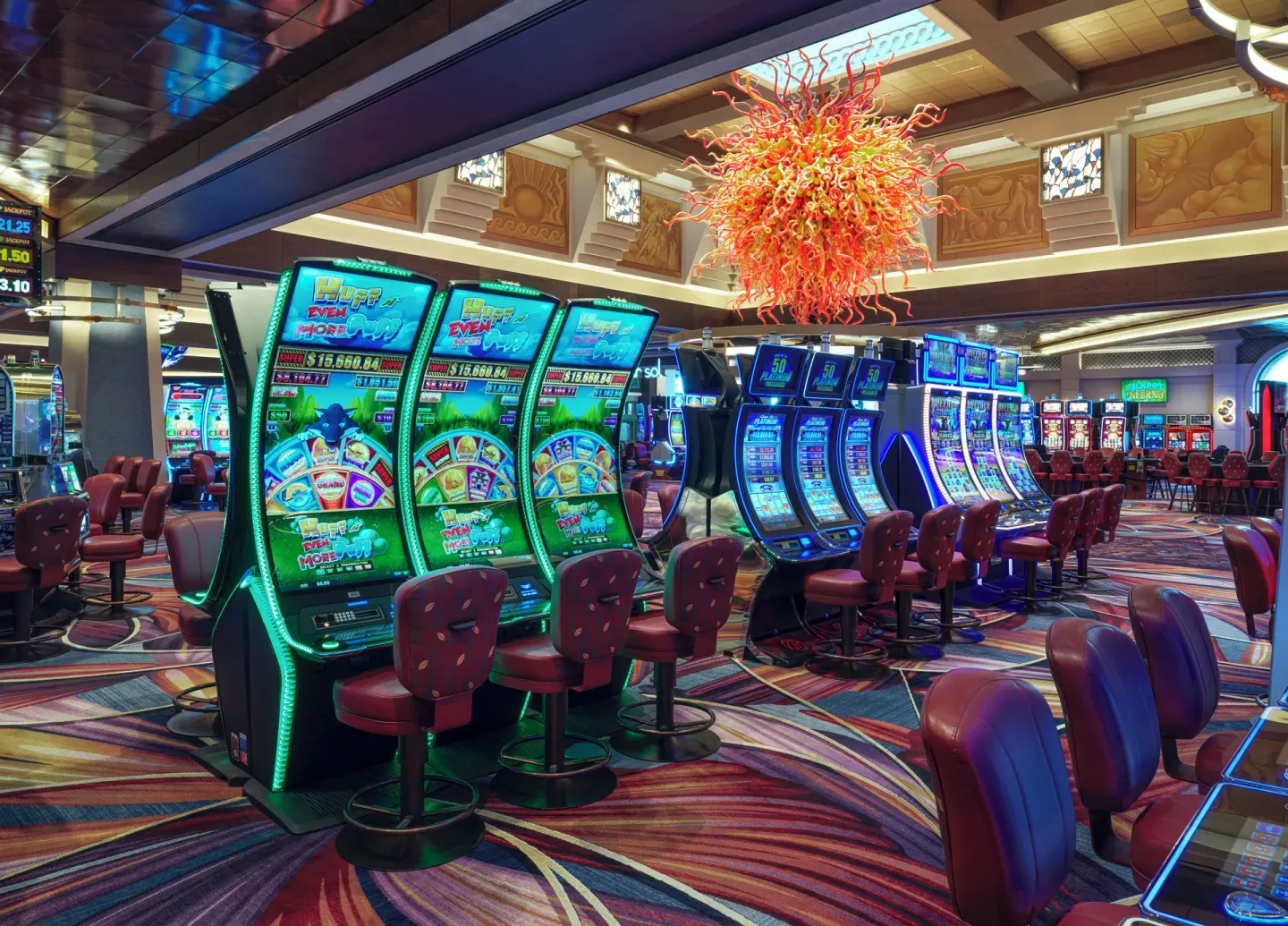 Rows of illuminated slot machines on the casino floor at The Reef at Atlantis.