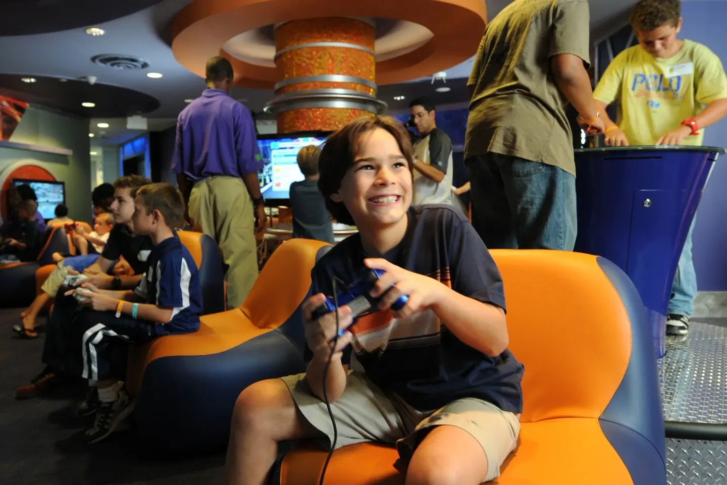 A child playing a video game in a colorful lounge at The Reef at Atlantis.