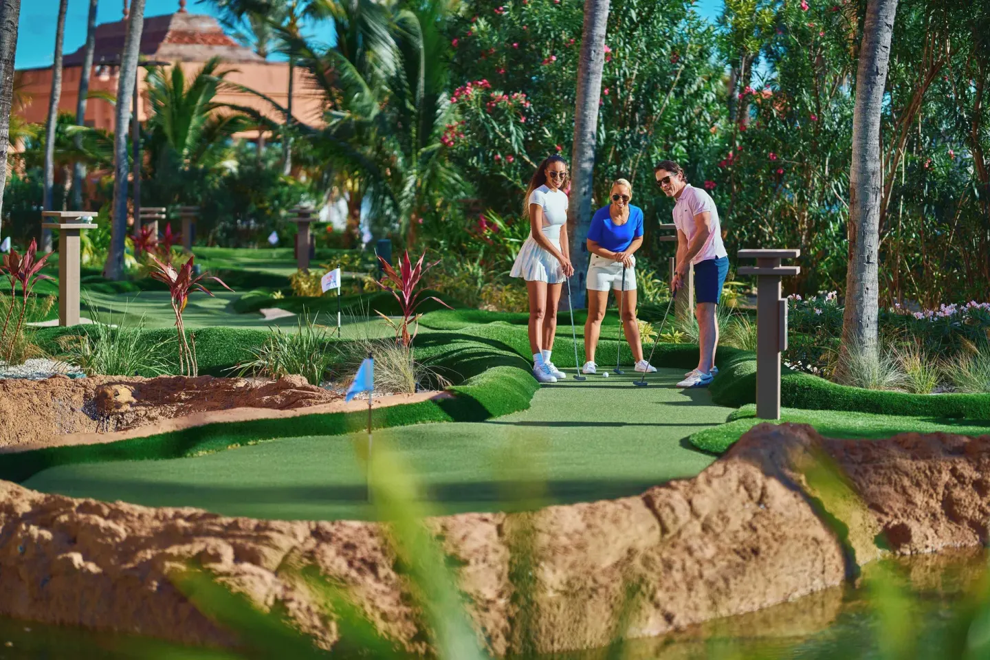 Guests play miniature golf among tropical landscaping at The Reef at Atlantis.