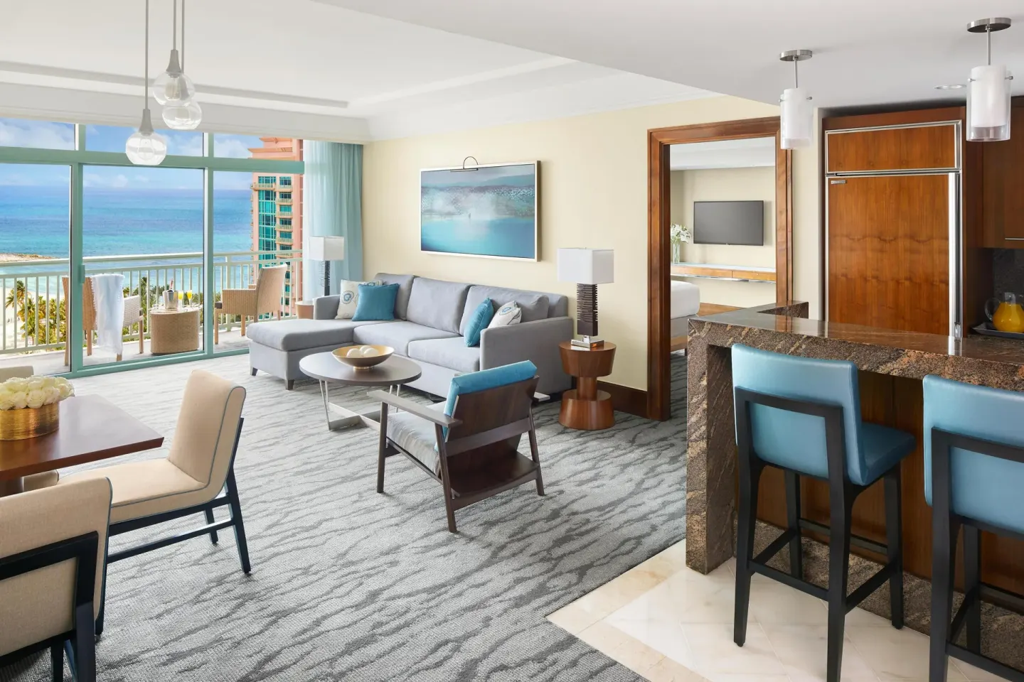 One Bedroom Ocean Suite living area with balcony and kitchenette at The Reef at Atlantis.