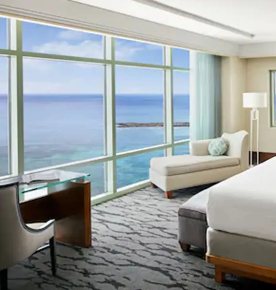 One Bedroom Topaz Suite bedroom seating and desk by ocean windows at The Reef at Atlantis.