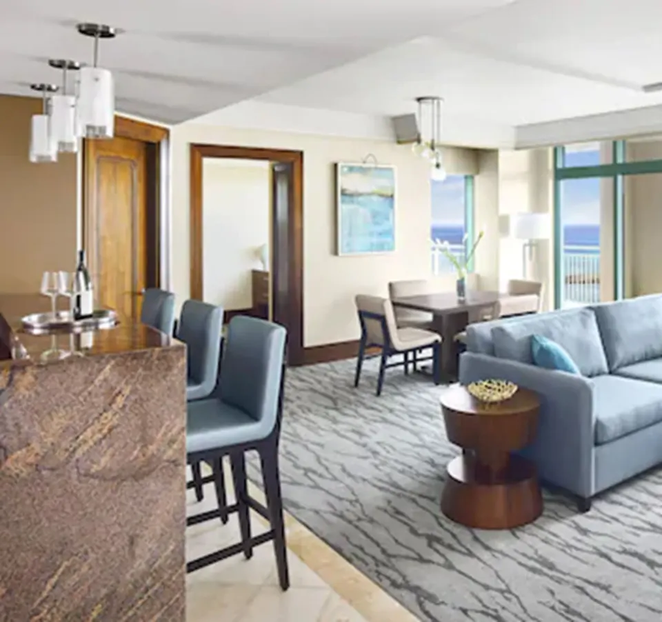 One Bedroom Topaz Suite living area with dining table and sofa at The Reef at Atlantis.