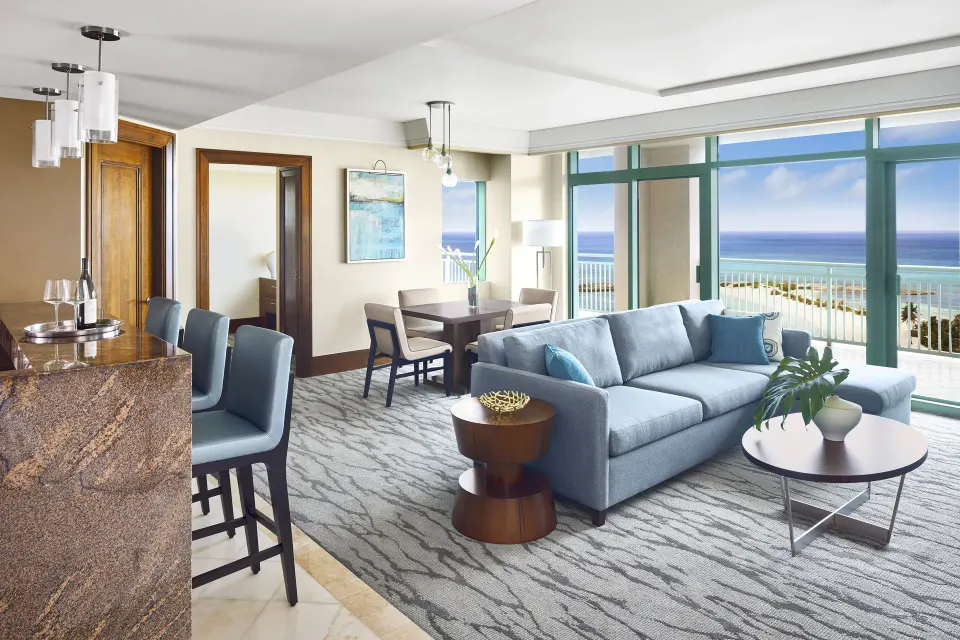 One Bedroom Topaz Suite living room with sofa and ocean-facing windows at The Reef at Atlantis.